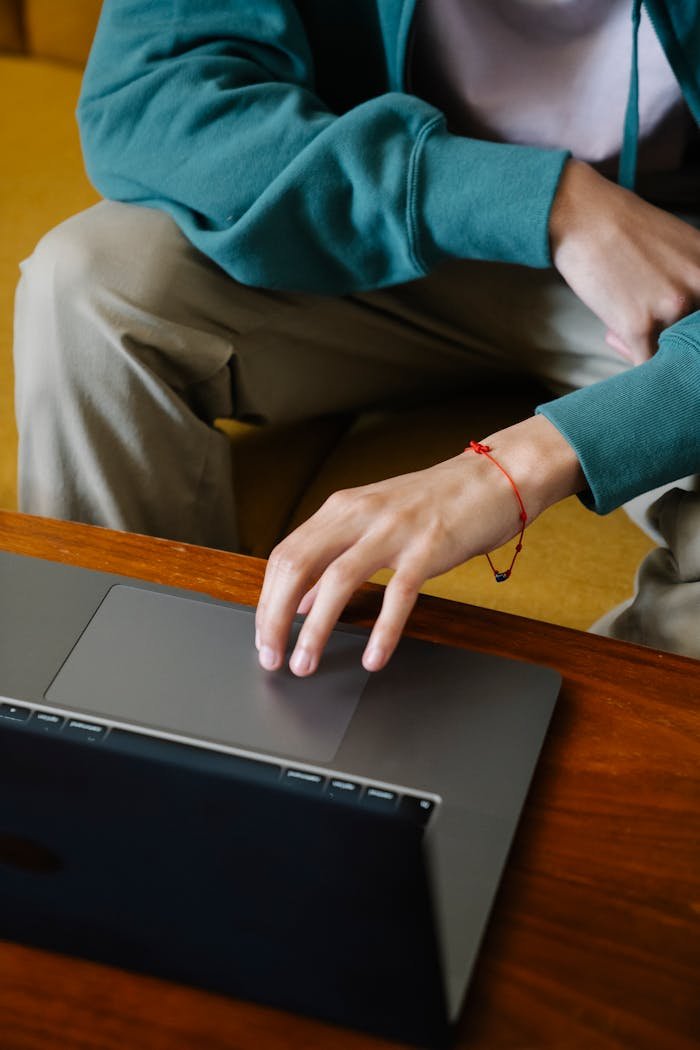 Close-up of a persons hand on a laptop touchpad, hinting at remote work or leisure browsing.